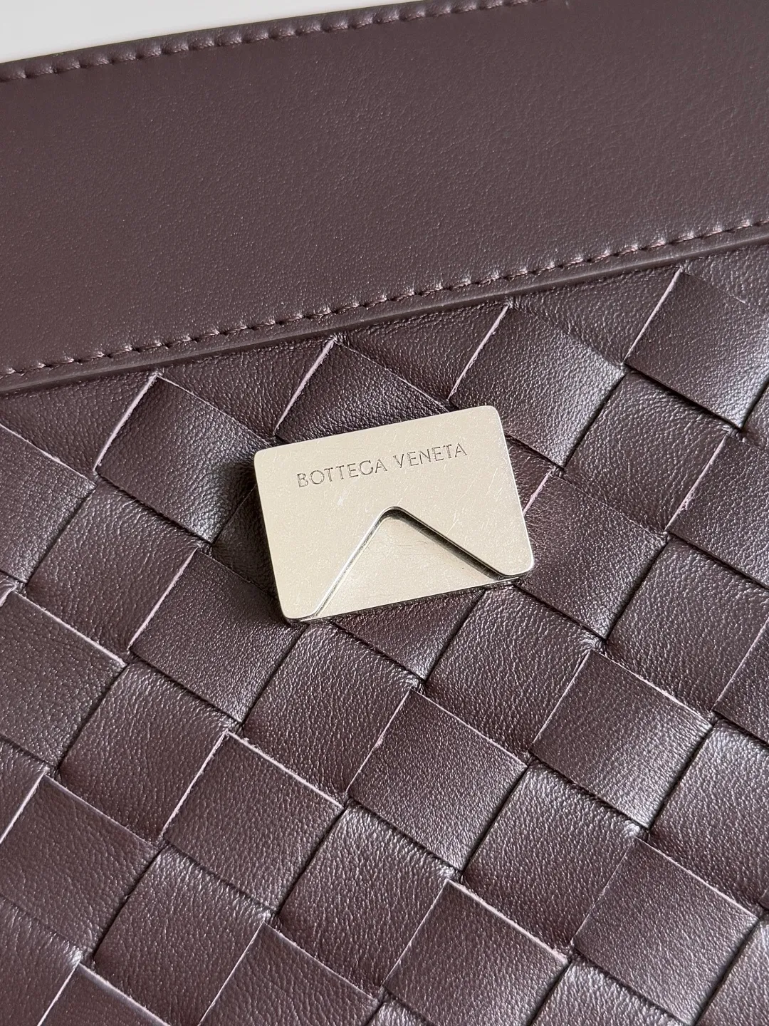 Batch 2460 BOTTEGA VENETA Bottega Veneta's 2025 new product for men ANDIAMO Bottega Veneta's main recommendation is undoubtedly the Andiamo small size. The first new favorite of the 2025 new product is a men's figure buckle bag. It can be seen that the designer has used many small ideas. The detachable crossbody strap is very convenient. It is convenient for elite office workers to reduce the burden on their hands when carrying work logs and office supplies. The interior is divided into two large compartments and a small zippered compartment. Unlike the women's model, the compartments here are not removable. The fixed large single layer also makes it easier to pack lightly when going out to work, and avoids the accumulation of too many small items. Style number: 815781 Size: 29*20*13cm